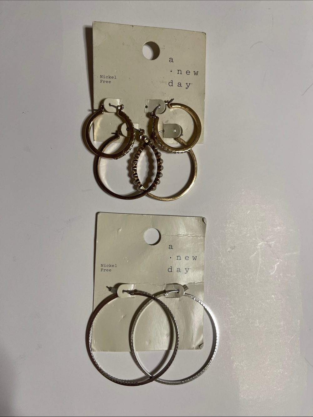 A New Day Gold tone Mixed Hoop Earring Set and a silver tone set.